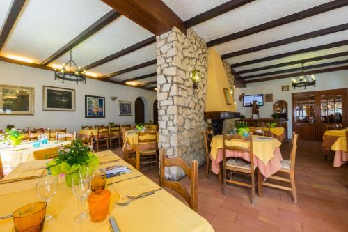 a restaurant with yellow tables and chairs and a stone pillar at Albergo Dalla Mena in Romano D'Ezzelino