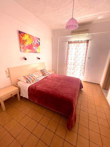 a bedroom with a large bed with a red blanket at Matala View in Matala