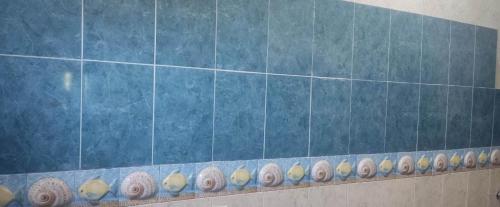 a blue tiled wall with a row of shells on a shelf at campo sano in Huimanguillo