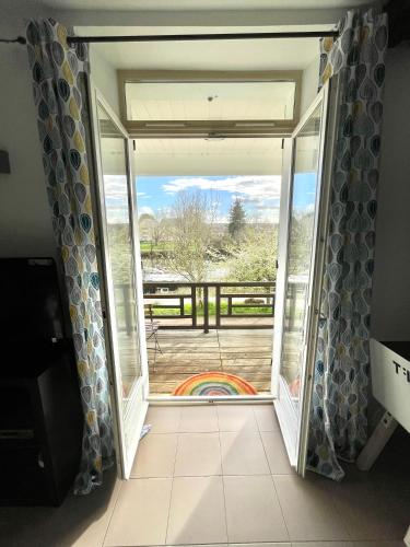 a door to a balcony with a view of a deck at T3-Balcon plein sud-Accès direct au bord du Loing in Moret-sur-Loing
