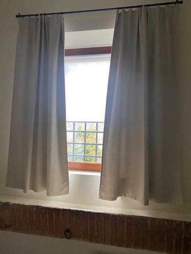 a window with a white curtain in a room at Sosta al Capitano in Pontassieve