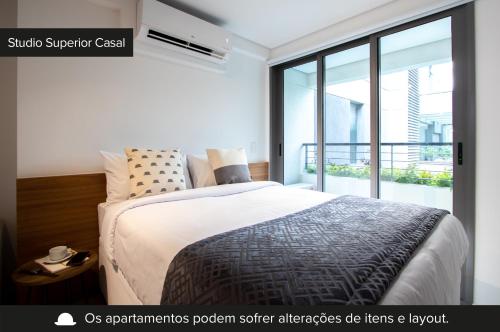 1 dormitorio con cama y ventana grande en Charlie Vila Nova Conceição Jacques Félix en São Paulo