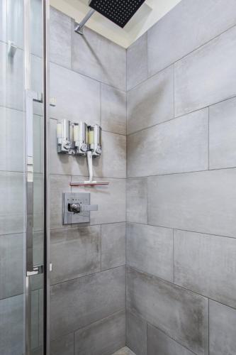 a shower with a glass door in a bathroom at Athena’s Hideaway- Fully Renovated- Absolute Best Location in Athens