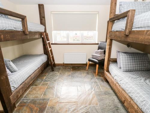 a room with two bunk beds and a chair at The Bike Shed in Disley