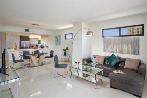 a living room with a couch and a table at Moderno Residences By Bay Breeze in Miami Beach