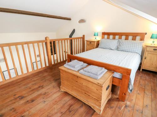 a bedroom with a bed and a wooden floor at The Hay Barn in Disley