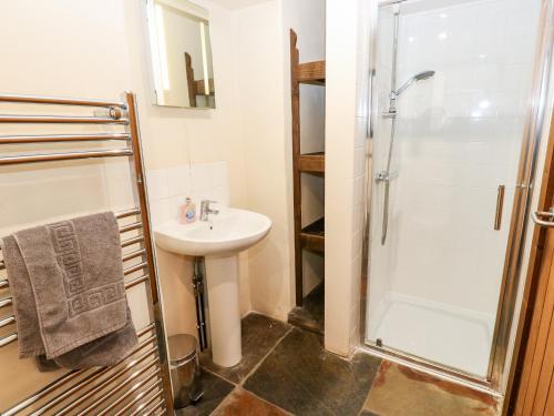 a bathroom with a sink and a shower at The Hay Barn in Disley