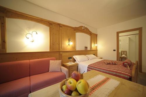 ブレツにあるLocanda Alpinaのソファ、フルーツボウルが備わるテーブルが備わる客室です。