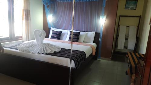 a hotel room with a bed with a swan on it at Sitha's Heaven in Ella