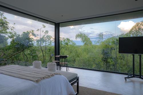 a bedroom with a bed and a large window at Palta Hotel in Pueblo Tapao
