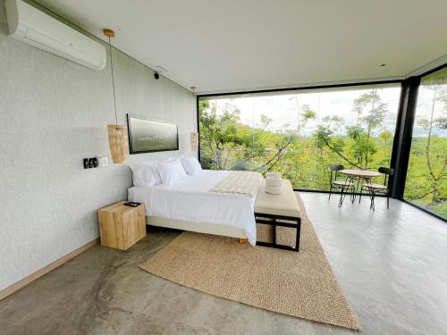 a bedroom with a bed and a large window at Palta Hotel in Pueblo Tapao