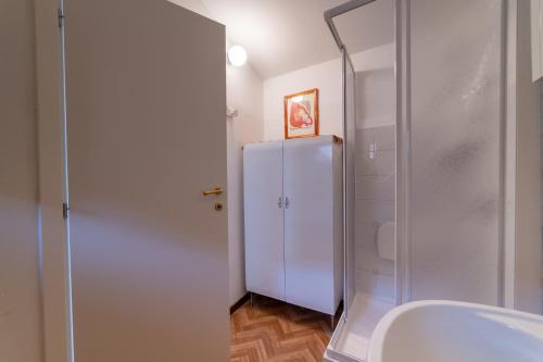 a bathroom with a shower and a white refrigerator at Appartamento Palazzo Barocci in Urbino