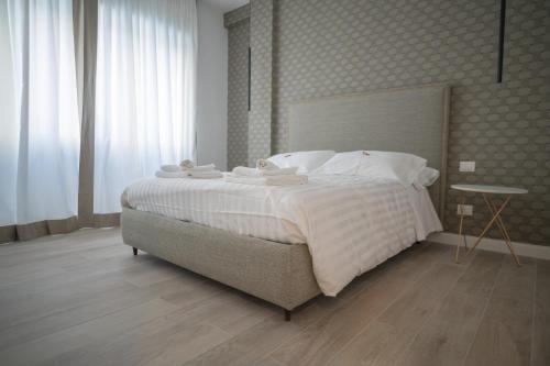 a bedroom with a large bed with white sheets at Gabri Guest House in Bari