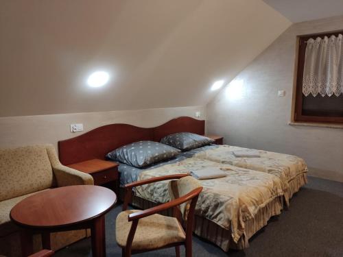 a bedroom with a bed and a chair and a table at Agroturystyka Kameralna93 in Ochaby