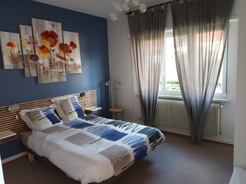 une chambre avec un grand lit aux murs bleus dans l'établissement Logis le 18 rose, à Strasbourg