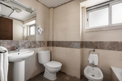 a bathroom with a toilet and a sink and a mirror at Crisol Tres Pastorinhos in Fátima