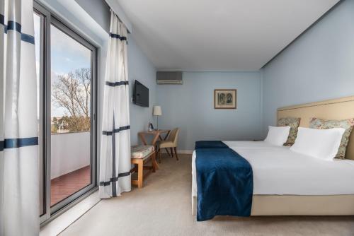 um quarto com uma cama e uma grande janela em Crisol Tres Pastorinhos em Fátima