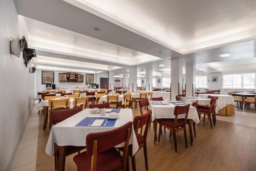 a dining room with white tables and chairs at Crisol Tres Pastorinhos in Fátima