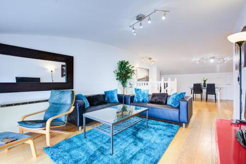 a living room with a blue couch and a table at Statera Apartments - Thames View in London
