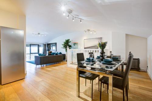 a dining room and living room with a table and chairs at Statera Apartments - Thames View in London