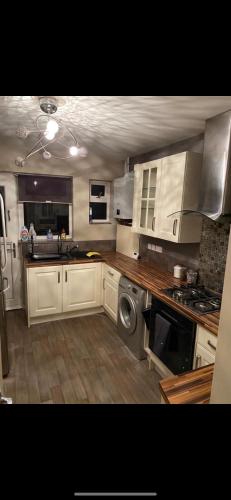 a kitchen with white cabinets and a sink and a dishwasher at Lovely Stay in Parkside