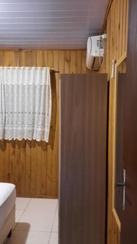 Cette chambre dispose d'une fenêtre avec un rideau et d'une douche. dans l'établissement Lindo Residencial na Praia Itapeva Torres, à Torres