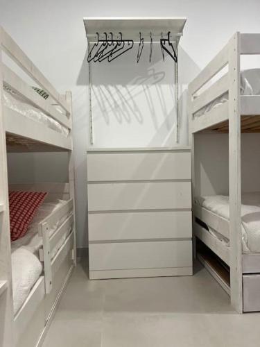 a white bedroom with two bunk beds in it at Villa Zeus in Rota