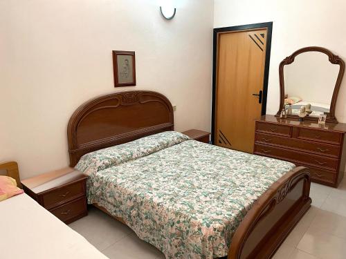 a bedroom with a bed and a dresser and a mirror at Villa Capozza Maria Greca in Le Castella