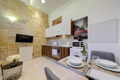 a kitchen with a table and chairs in a room at Tritoni Harbour suites - Valletta in Valletta