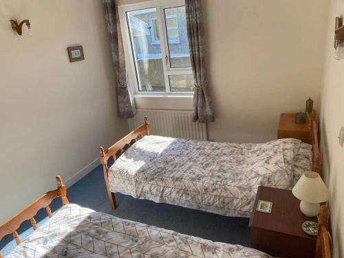 a bedroom with two beds and a window at Ballyliffin bungalow with stunning beach views in Ballyliffin