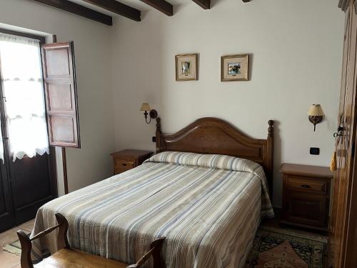 um quarto com uma cama com um edredão listrado e uma janela em Posada San Tirso em Toñanes