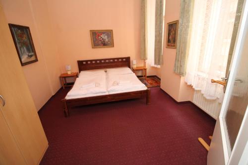 卡羅維發利的住宿－Delux Kolonada，卧室位于客房的角落,配有一张床