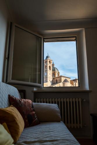 a view of a clock tower from a window at Appartamento Palazzo Barocci in Urbino