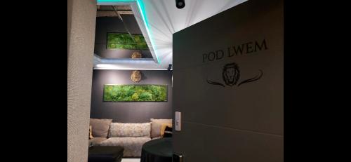 a living room with a couch and paintings on the wall at Pod Lwem in Kościerzyna
