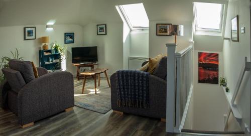 a living room with two chairs and a television at The Walk-up in Portree