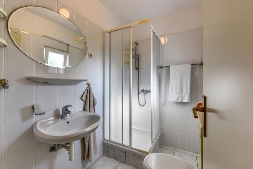 ein Bad mit einem Waschbecken, einem Spiegel und einer Dusche in der Unterkunft Haus Manda - Wohnung 6 in Ražanac