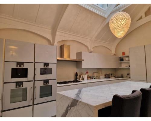 a kitchen with white appliances and a chandelier at Victoria Square in London