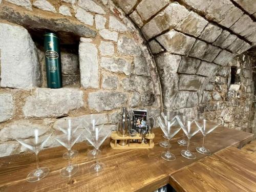 a group of wine glasses sitting on a wooden table at Lydney House Swaffham Sleeps 22 in Swaffham