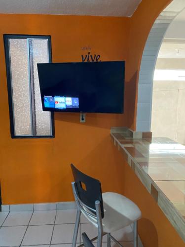 a waiting room with a chair and a tv on a wall at Alojamiento Vacacional Casa Conchalito in La Paz