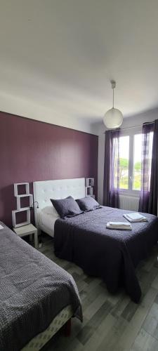 a bedroom with two beds and a large window at Hôtel l'Etoile in Le Grau-du-Roi