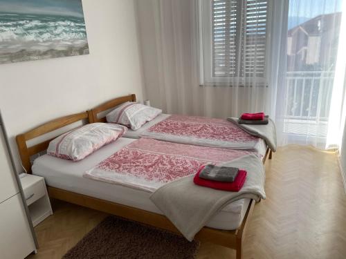 a bedroom with two beds and a large window at Casa Estancia Apartment in Njivice