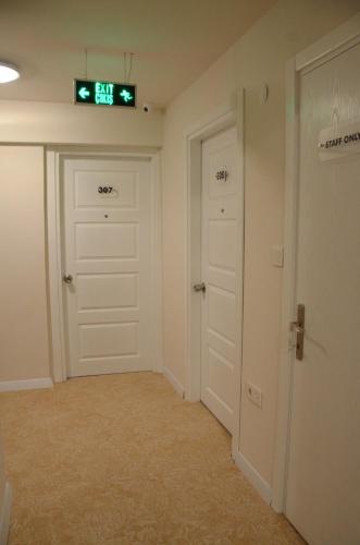 an empty room with two doors and a clock on the wall at ParionHouse Hotel in Canakkale