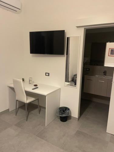 a white desk with a chair and a television on a wall at B&B UN POSTO AL MARE San Salvo Marina in San Salvo