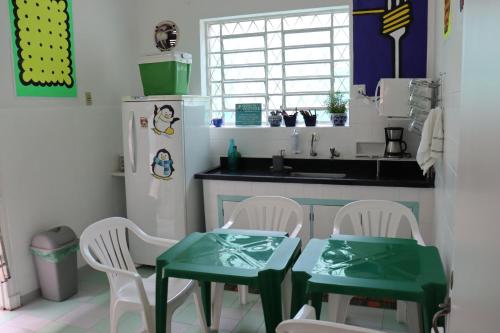 uma cozinha com uma mesa e cadeiras e um frigorífico em Mondo Verde Hostel em São Paulo