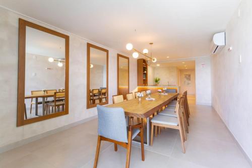 a dining room with a wooden table and chairs at Beira-Mar Boa Viagem - Ivone Asfora by Bnb Flex in Recife