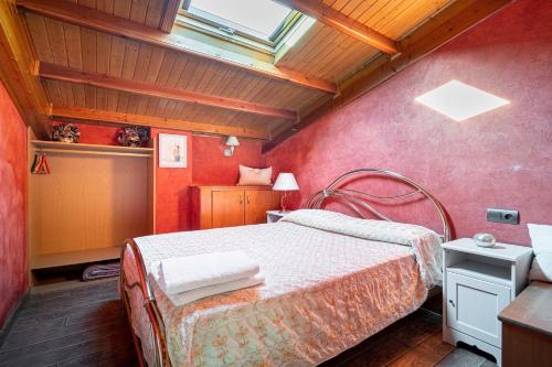 a bedroom with a bed with red walls and a window at Luxury Valdeorras in Valdegodos