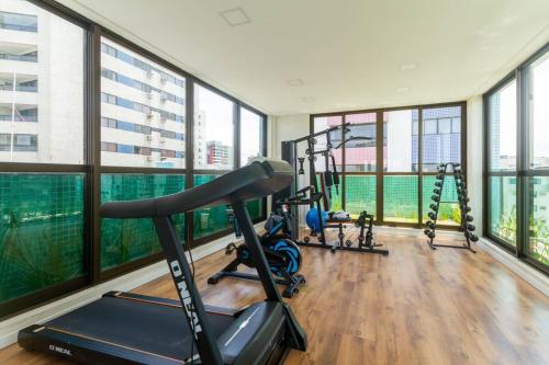 un gimnasio con varias máquinas de correr y ventanas en Beira-Mar Boa Viagem - Ivone Asfora by Bnb Flex, en Recife
