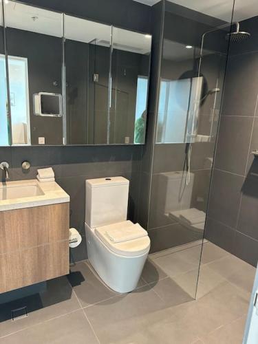 y baño con aseo, lavabo y ducha. en Modern 2 BRM Apt in Williamstown, en Williamstown