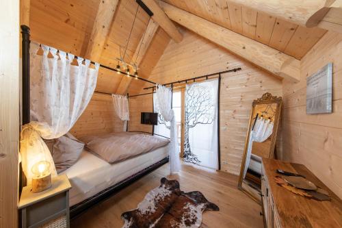 ein Schlafzimmer in einem Blockhaus mit einem Bett und einem Fenster in der Unterkunft Biochalet Haus 1 in Gleinstätten