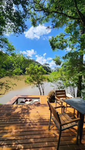 een houten terras met twee banken en een tafel bij Arau Cabana Cheiro de Mato in Flores da Cunha